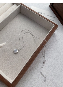 Macro shot of S999 sterling silver sugar cube necklace with sparkling zircon on tray