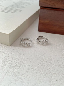 Detail shot of S925 sterling silver hoop earrings with hollow daisy flower design