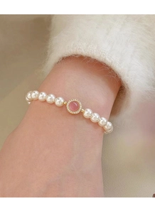 Macro shot of S925 silver bracelet with white pearls and pink gemstone center charm