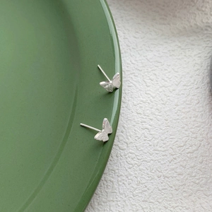 Boucles d'oreilles papillon en argent S999 avec ailes texturées sur fond vert