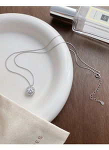 Detailed close-up of S925 sterling silver square halo pendant with box chain on white disk