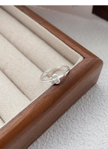 Vue macro de la bague iris en argent S925 avec pierre précieuse sur plateau à bijoux en bois