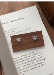 Détail de boucles d'oreilles cœur en argent fin S999 avec étoile sur bois vintage