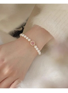 Close-up of S925 silver pearl bracelet with a pink opal center and sparkling accents