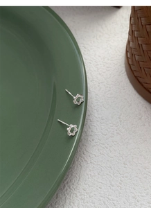Gros plan sur des boucles d'oreilles étoiles en argent S925 avec texture de corde