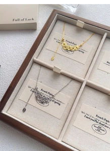 Macro shot of gold and silver coin necklaces displayed in a wooden jewelry box
