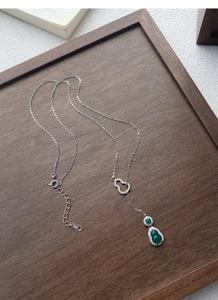 Vista dettagliata della collana in argento S925 con gocce di gemme verdi e ciondolo a zucca