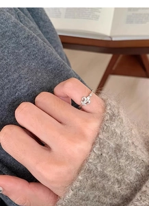 Vue détaillée d'une bague fleur de lys en argent S925 portée sur la main d'un mannequin