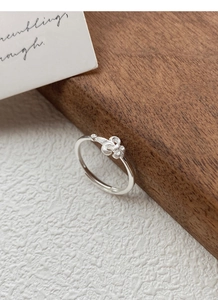 Détail macro d'une bague fleur d'iris en argent avec texture mate et anneau réglable