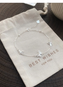Gros plan d'un bracelet papillon en argent massif S925 montrant les détails de gravure laser