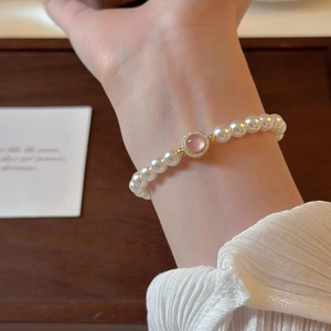 Elegant S925 silver bracelet with white pearls and a pink gemstone in gold setting