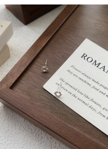 Gros plan de boucles d'oreilles étoile évidée en argent S925 sur une carte poétique