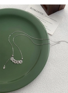 Macro detail of S925 silver necklace featuring five interlocking textured coin rings