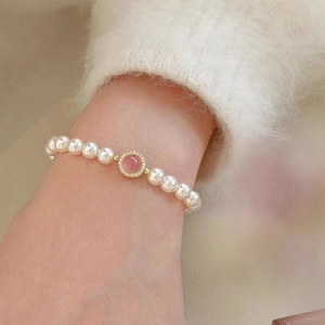 S925 sterling silver pearl bracelet with pink gemstone centerpiece worn on a wrist