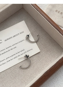 Macro shot of S925 sterling silver twisted rope knot earrings with vintage retro finish