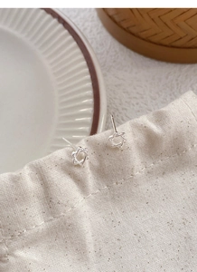 Boucles d'oreilles hexagramme en argent S999 présentées sur une pochette en lin