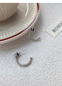 Macro detail of S925 sterling silver knotted rope earrings with vintage oxidized finish
