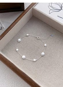 Close-up of S925 sterling silver frosted beads on a bracelet in a wooden jewelry tray