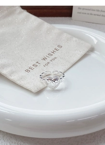 Detailed macro shot of an adjustable heart ring with hammered texture on a ceramic plate