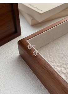 Vue détaillée des boucles d'oreilles hexagramme en argent sur un plateau en bois