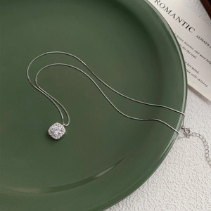 S999 sterling silver necklace with square zircon pendant on elegant green ceramic plate