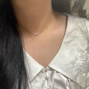 Élégant collier en argent sterling S925 doré avec trois zircons brillants sur un modèle