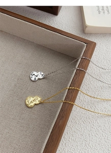Detail of S925 sterling silver gourd pendants with hammered texture in gold and silver