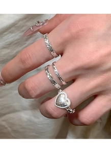 Macro view of S925 silver heart ring set with textured hammer finish on female hand