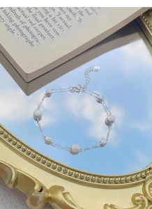 Close-up of S925 sterling silver double-layer bracelet with frosted beads on mirror surface