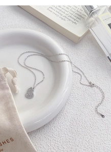 Detail shot of S925 sterling silver gourd pendant with dragon scale texture on white ceramic