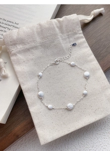 Detail of S925 sterling silver bracelet with matte beads on a rustic fabric bag