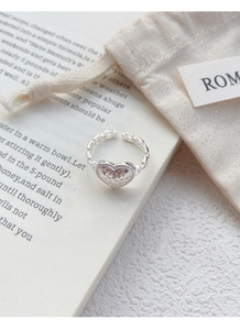 Detail of S925 silver heart ring with hammered texture on vintage book background