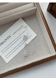 Detailed macro shot of S925 sterling silver hoop earrings with delicate beaded flower charms