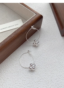 Macro shot of S925 sterling silver hoop earrings with spiral texture and polished metal beads