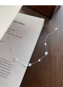 Detail of S925 sterling silver frosted round bracelet with adjustable chain on a book