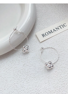Detailed macro view of S925 sterling silver hoop earrings with textured twist and bead charms