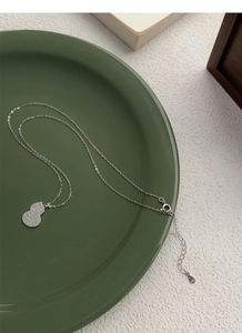 Macro shot of S925 sterling silver gourd pendant with intricate Ruyi texture details