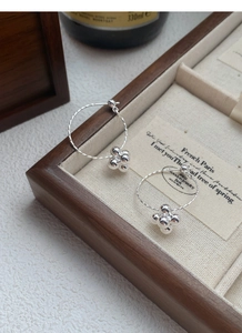 Detailed shot of S925 sterling silver hoop earrings with textured spiral and bead drops