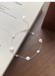 Macro detail of S925 sterling silver bracelet featuring matte frosted pebble charms