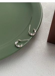Close-up of S925 sterling silver Mobius stud earrings with unique twisted spiral design