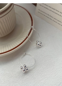 Close-up of S925 sterling silver hoop earrings with textured twist and bead flower drops