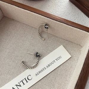 Vintage S925 sterling silver twisted rope knot earrings displayed in a wooden jewelry box