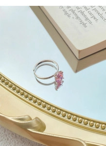 Close-up of pink zircon silver ring on a vintage mirror with elegant reflections