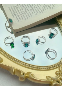 Macro shot of silver emerald rings with geometric zircon on a vintage mirror