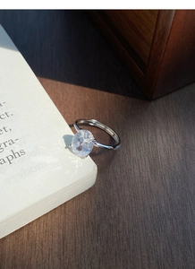 Macro shot of silver ring featuring a sparkling oval zircon in a four-prong setting