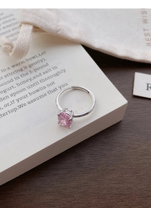 Detailed view of pink zircon S925 silver ring with adjustable band on a book