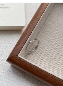 Detailed view of S999 sterling silver ring with a sparkling solitaire zircon in wood tray