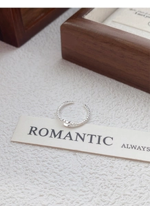 Detailed shot of an S925 sterling silver beaded bow ring on a romantic gift card