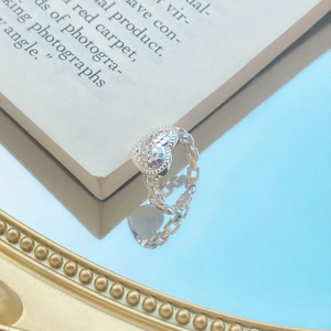 Chic S925 sterling silver heart ring with chain-link band on blue mirror surface