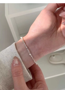 Macro shot of S925 sterling silver chain with a small star pendant on a female wrist